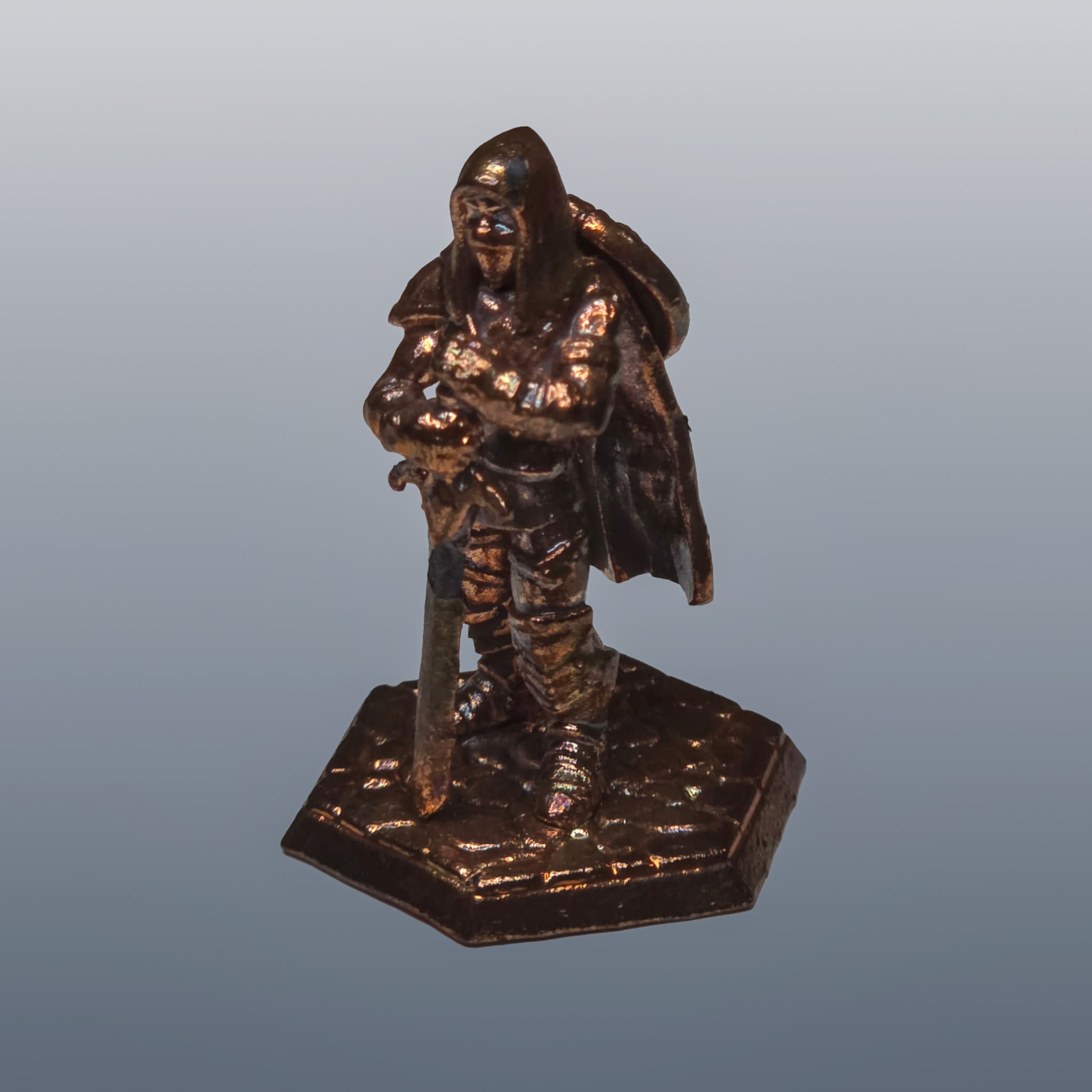 A copper-plated tabletop miniature standing on a hexagonal base